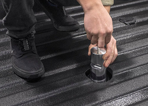 A man installing his simple, easy, and sturdy Andersen Bed Shaft in his truck bed.