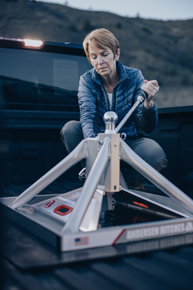 Older woman installing the Andersen Hitches Ultimate 5th Wheel Connection in the bed of a pickup truck using hand tools.