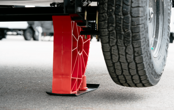 Andersen Hitches Single Axle Rapid Jack (S.A.R.J.) lifting a trailer tire on asphalt with the adjacent tire raised off the ground.