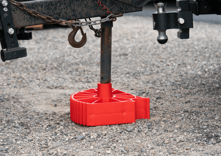 The Single Axle Rapid Jack (S.A.R.J) placed flat on the ground with chock secured in position. The chock is adding height to the SARJ which helps with a trailer post jack.
