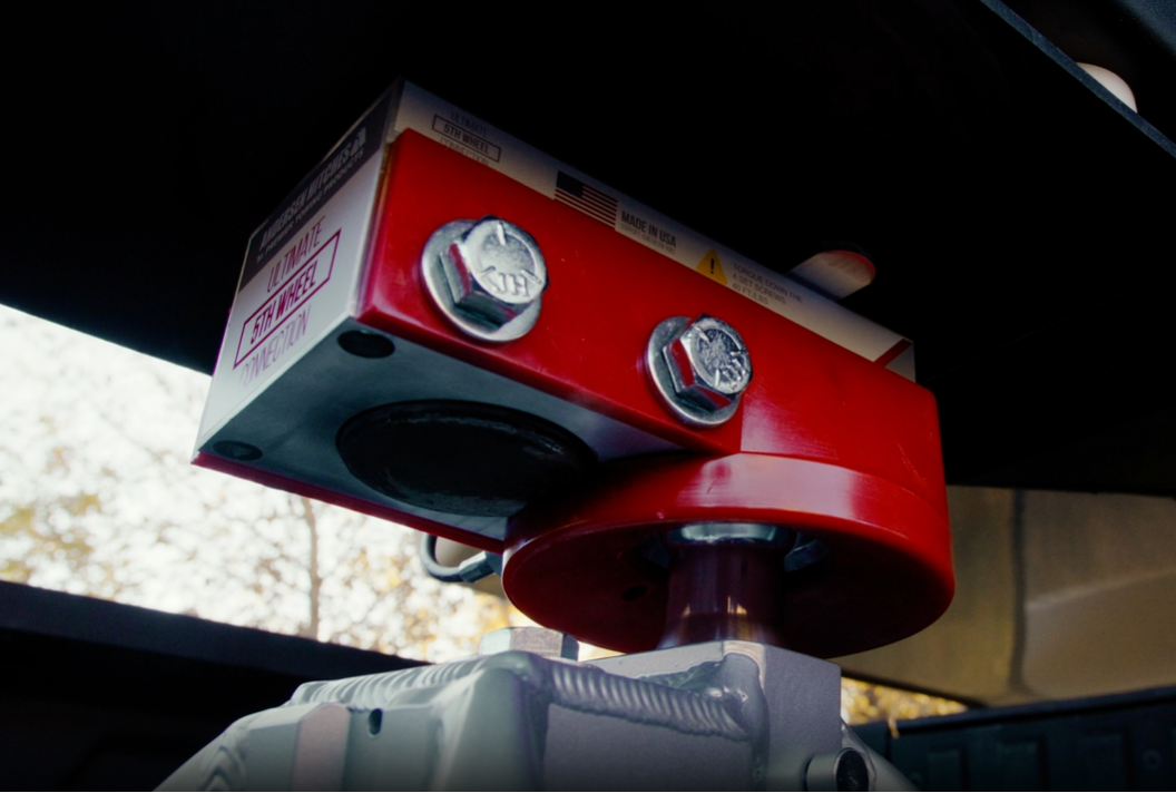 Showing Ultimate Connection Kingpin Coupler – complete assembly with funnel getting lowered and connected to a Ultimate 5th Wheel Connection in the back of a pickup truck.