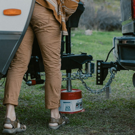 Andersen Hitches Weight Distribution Hitch on Trailer Back Block. A man is standing over the hitch and jack block.