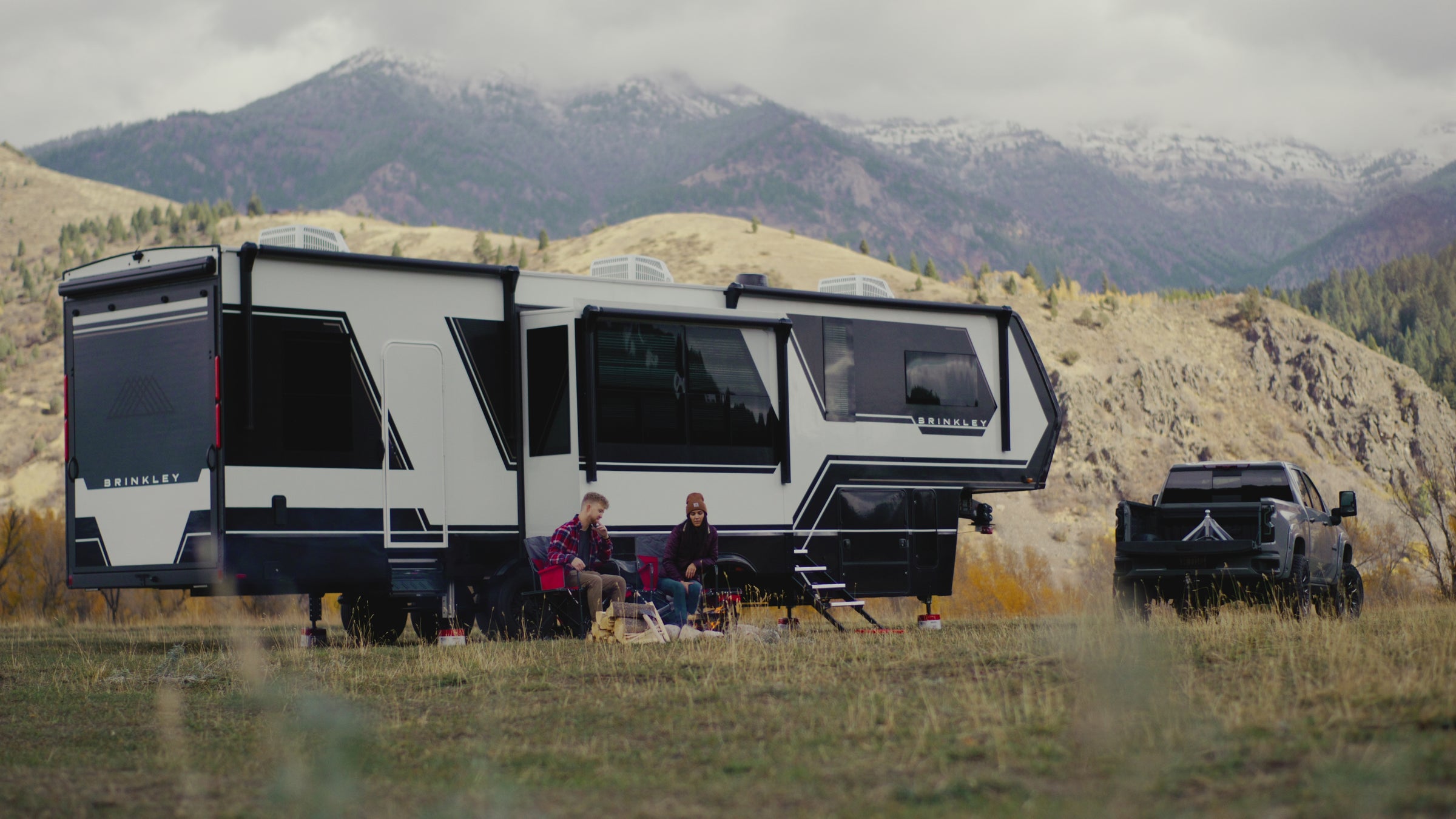 Andersen Hitches Ultimate 5th Wheel Connection promotional video showcasing a lightweight, 40-pound aluminum hitch. The video demonstrates towing a Brinkley RV with a heavy-duty truck, highlighting a 24,000 lbs GTWR capacity and 97-year lifetime warranty. Key features shown include the adjustable ball height, built-in ball funnel for easy hitching, and full articulation to reduce chucking and jerking for a smooth ride. The footage emphasizes the ease of installation and removal, allowing for full truck bed